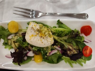 Burrata Cheese atop a fresh garden lettuce mix with San Marzano tomatoes, coated with a lemon infusion dressing